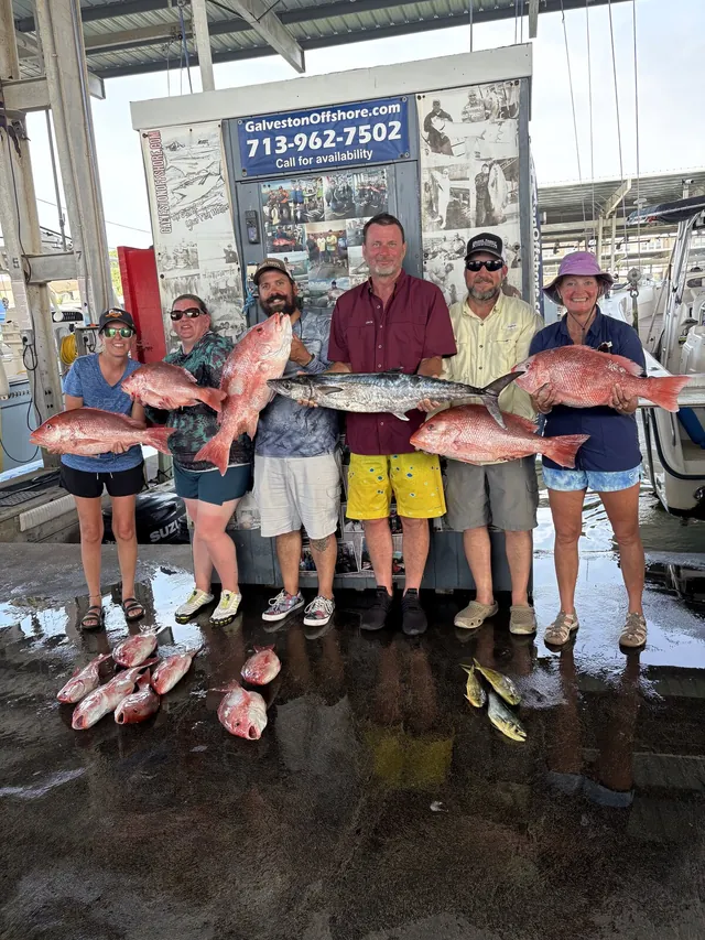 Capt. Shannon and a young angler holding a large red snapper on the deck of Half Time