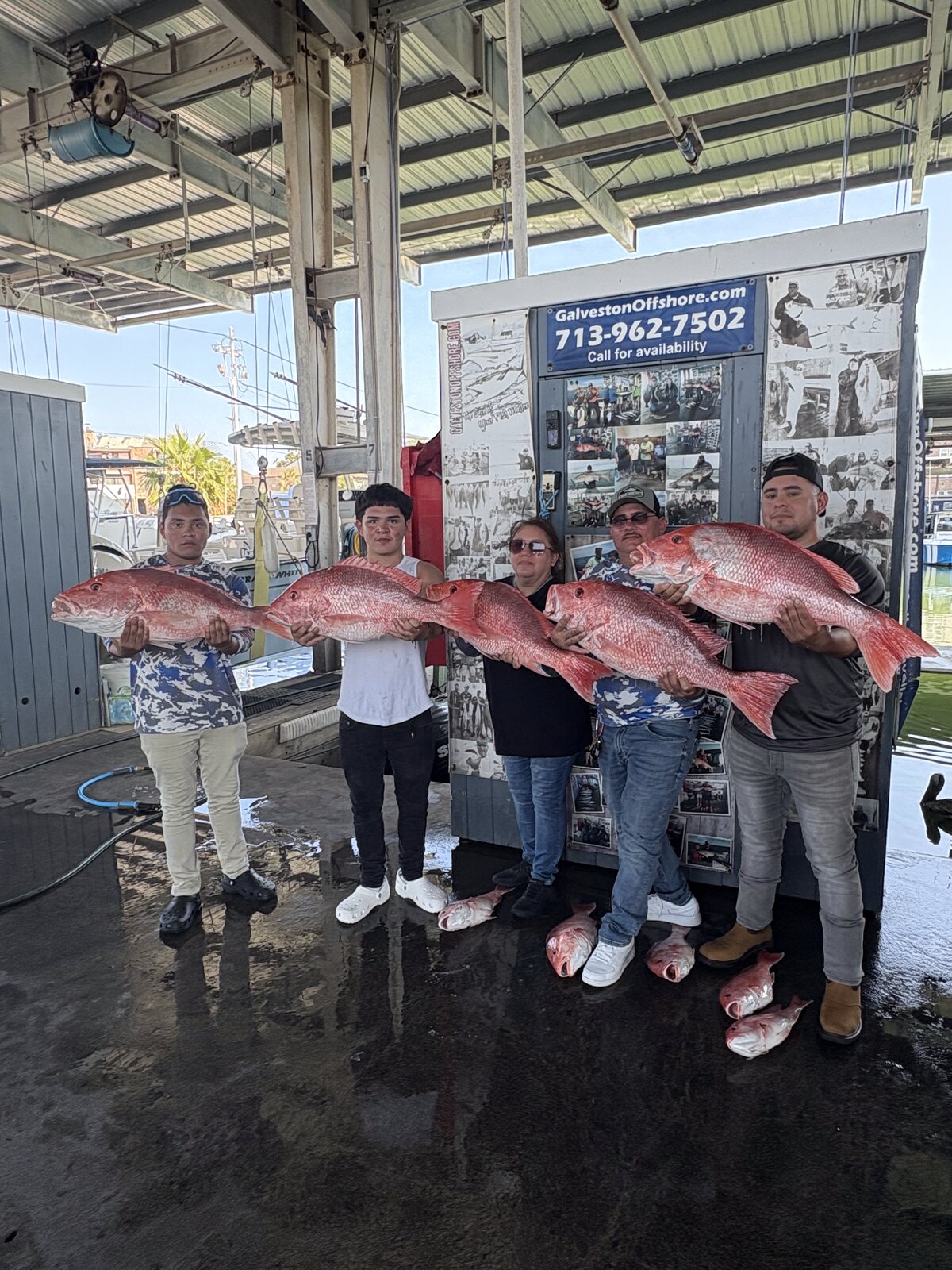 Five anglers at the Galveston Offshore dock holding five large red snapper after a federal offshore trip