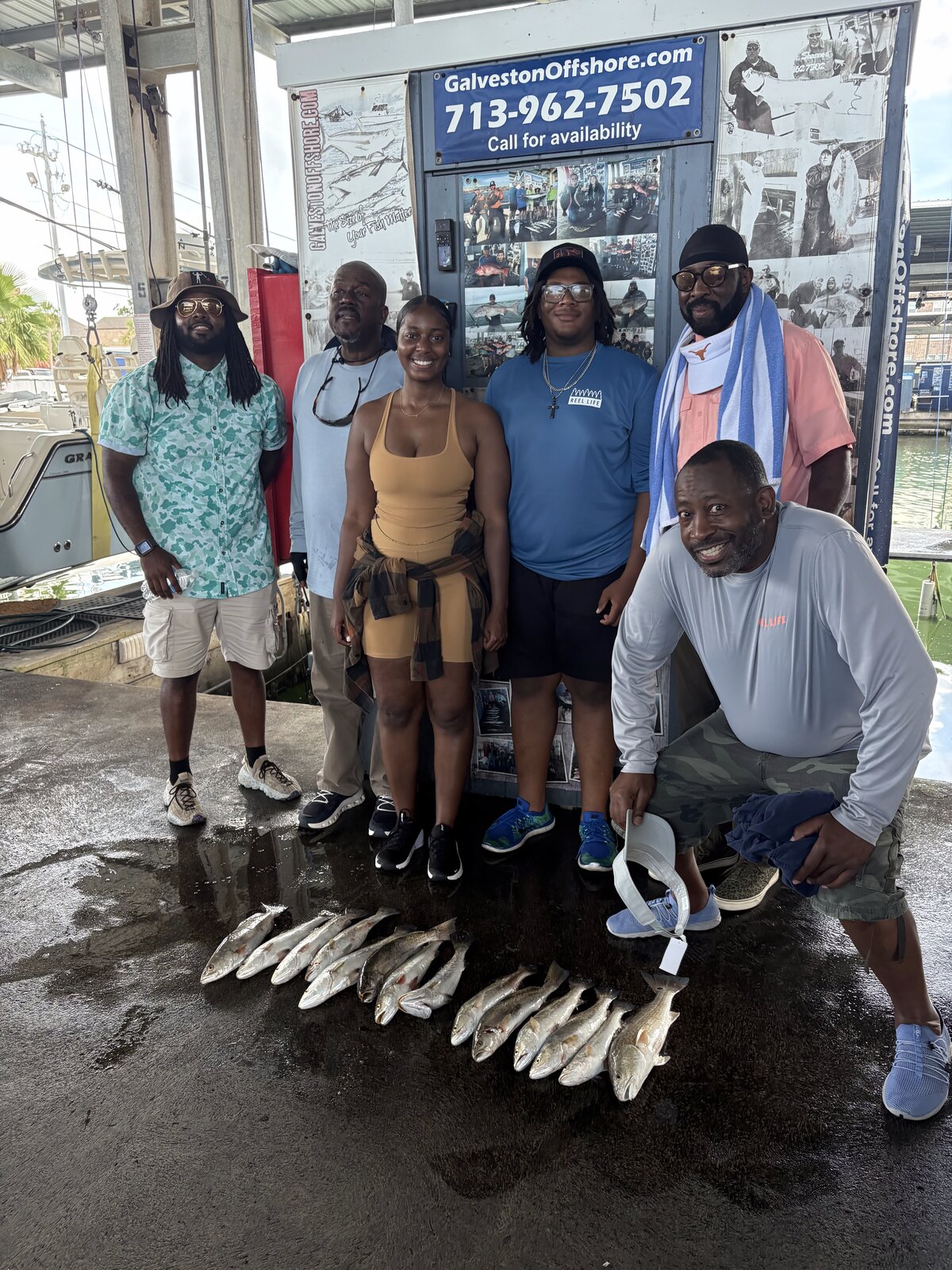 Family group at the Galveston Offshore dock with a row of speckled trout from a jetty fishing trip