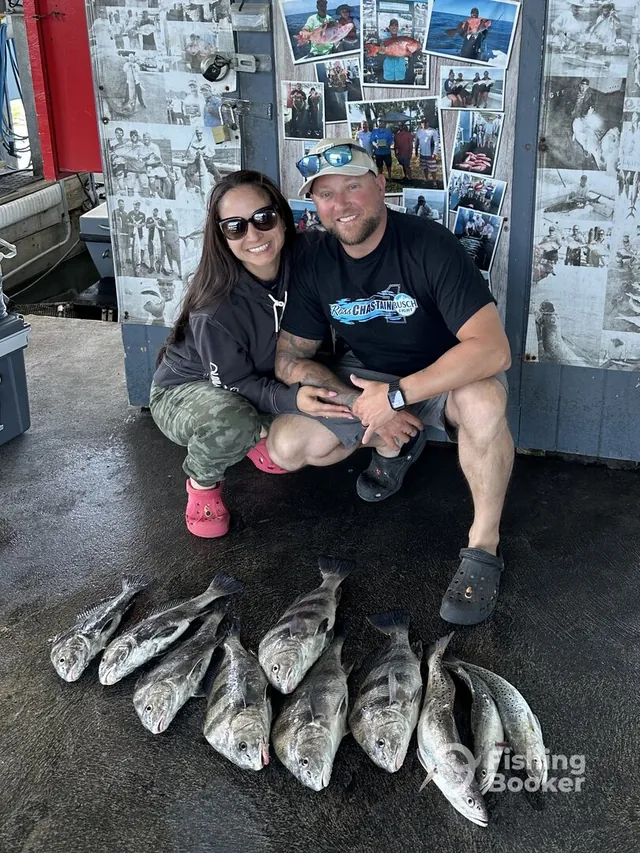 A couple at the dock with a haul of black drum and speckled trout