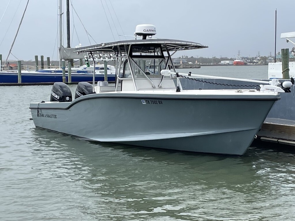 The 31 ft Ocean Master Half Time docked, twin Suzuki 300s mounted