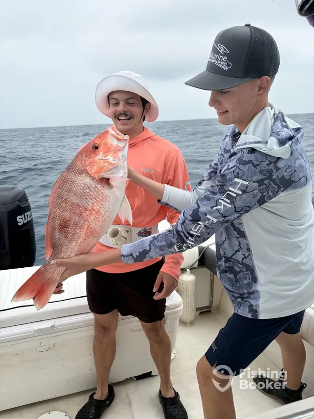 Two anglers holding red snapper at the same time offshore aboard the Half Time